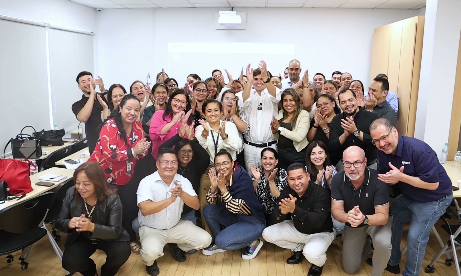Equipo de una cadena celebrando su transformación del servicio en un seminario del Método CIOM